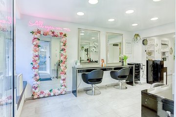 Heller Innenraum des Friseursalons Supreme Hair mit Stylingplätzen und floralem Dekor